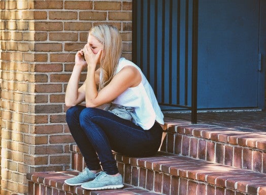 image of a woman sitting on steps crying.