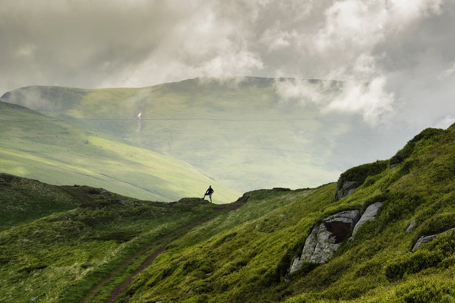 landscape shot of a hiker on a mountain ridge.