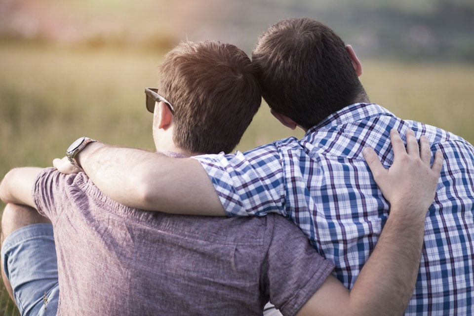 lgbtq men with arms around each others shoulders